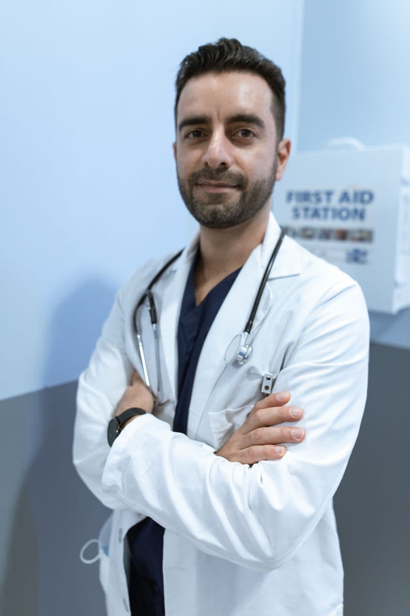 Portrait of Dr. Nathan Park, DMD, MS, a male clinician in a white coat with a stethoscope, arms crossed