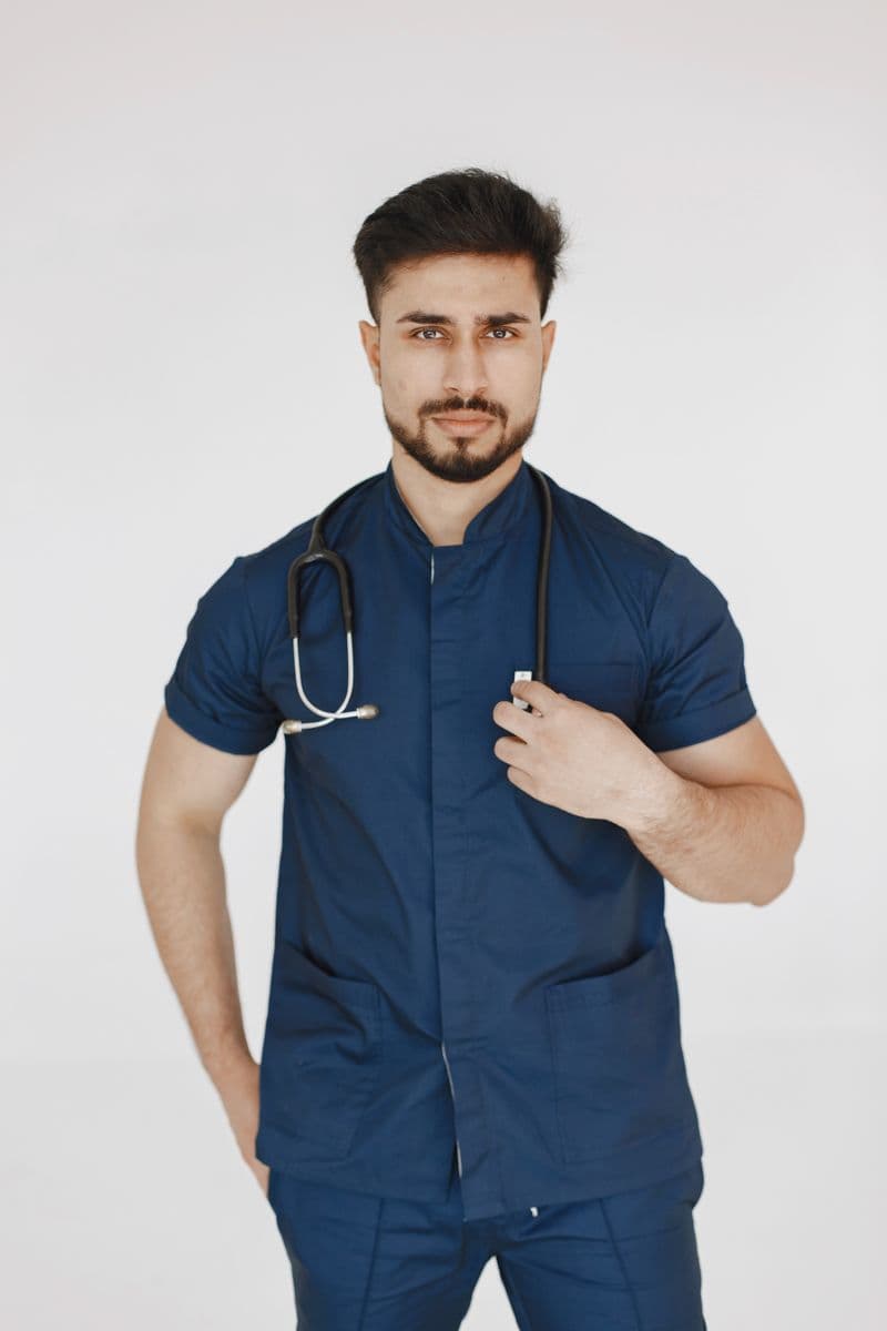 Portrait of Jordan Ellis, RDA, a male clinical assistant in blue scrubs with a stethoscope