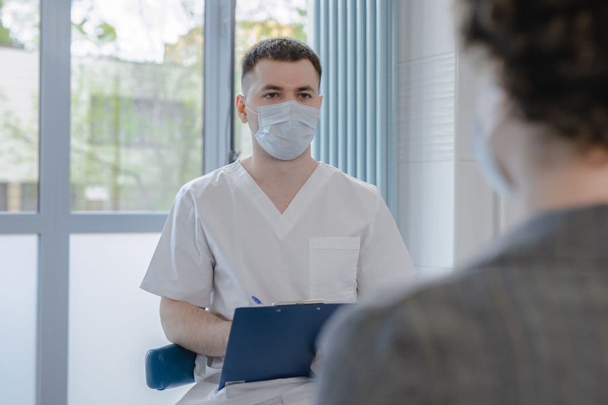 A clinician reviewing notes with a patient during a consultation